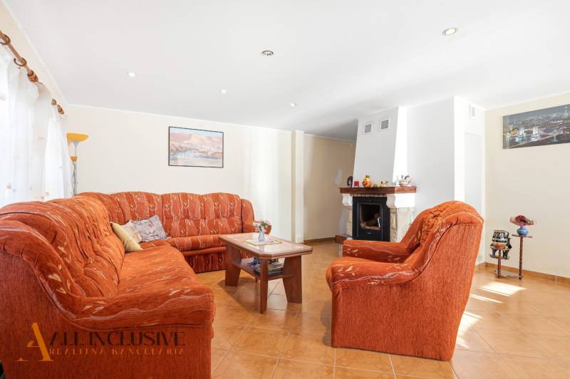 Living room with a sofa and a fireplace in a cabin with a wood-decorated floor.