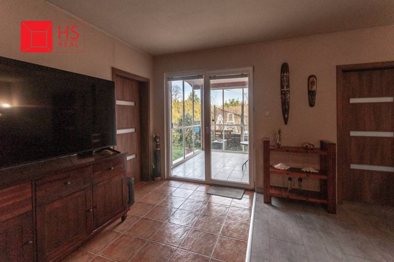 Living room with a large TV and access to the terrace in a family house.