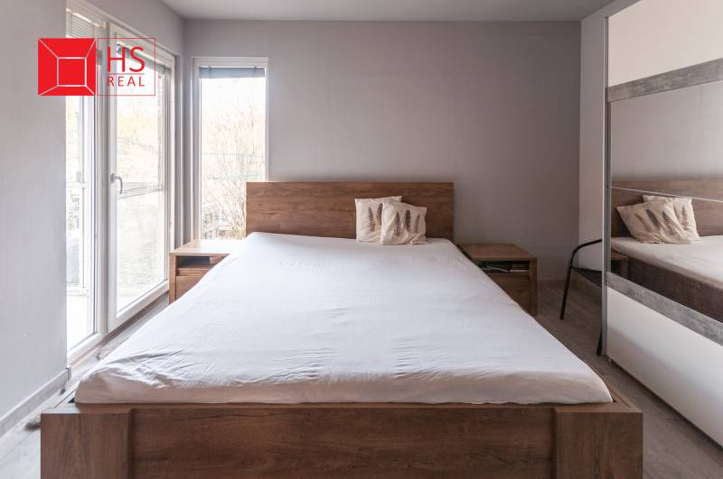 A bedroom with a large bed and a mirrored wardrobe in a family house.