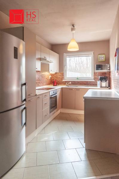 A kitchen unit in a family house with brick cladding and built-in appliances.