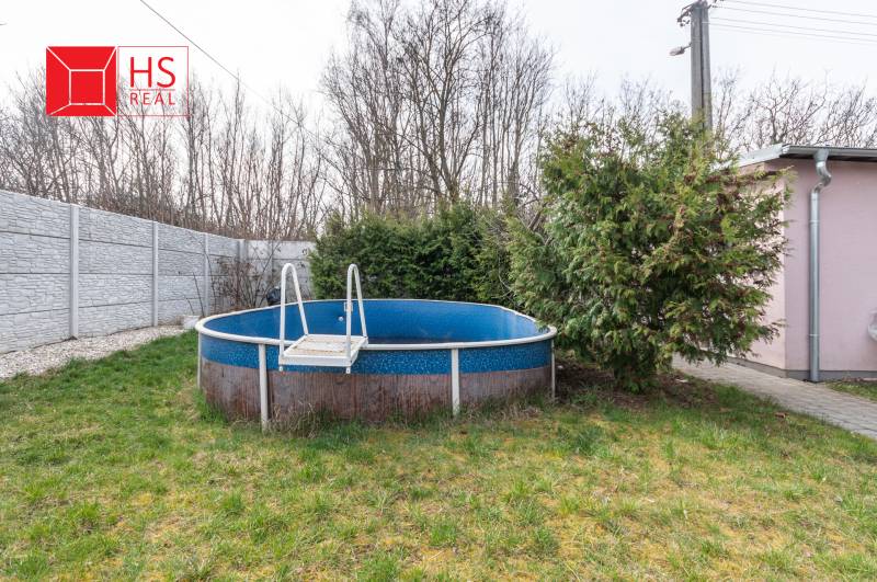 A family house in Šurany with a garden, a swimming pool, and dense vegetation for privacy.