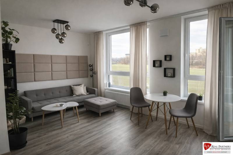 Living room with a sofa, tables, and a wooden decor floor in a 2-room apartment.