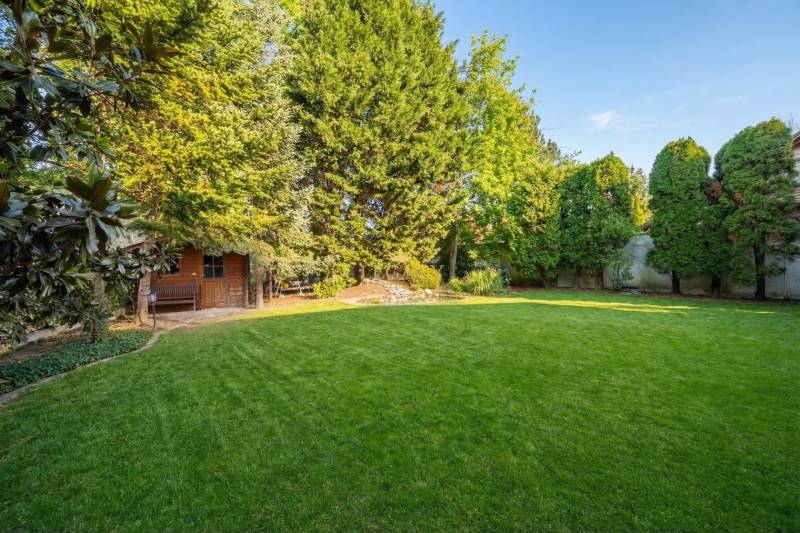 A garden at a family house in Ivanka pri Dunaji with a well-maintained lawn and a wooden house.