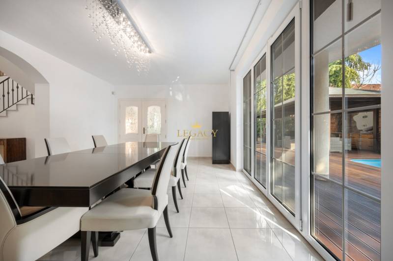 Dining room in a family house with a long table and a view of the terrace.