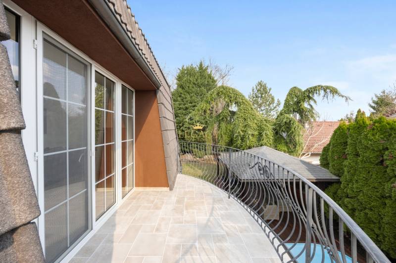 A balcony of a family house in Ivanka pri Dunaji with a metal railing and a view of the garden.
