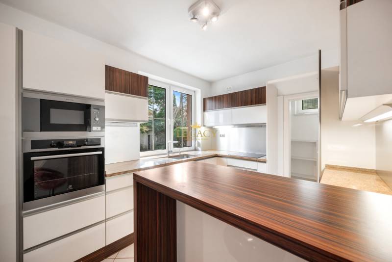 A kitchen with a wood-patterned floor and white cabinets in a family house.