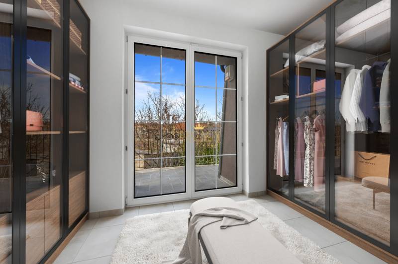 A wardrobe in a family house with sliding closets and a view of the terrace.