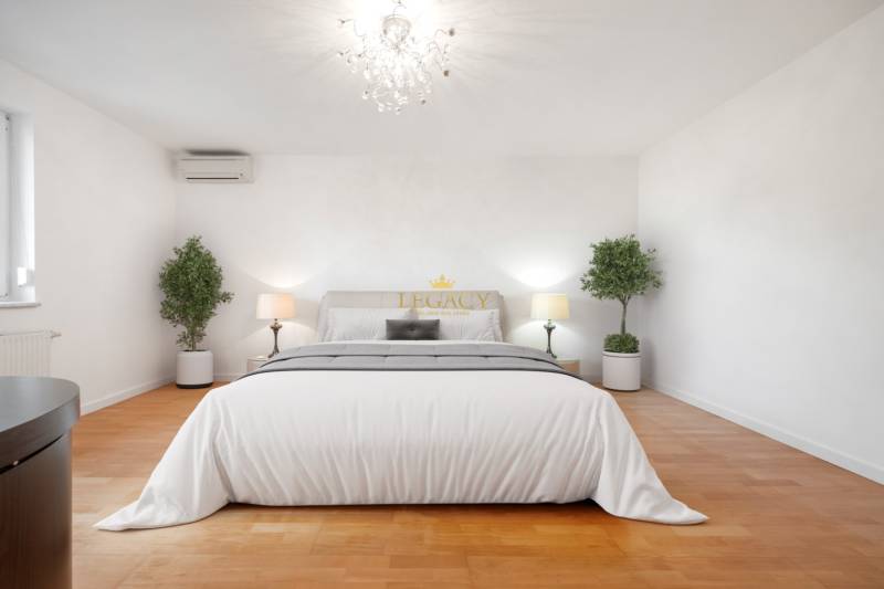 Cozy bedroom with an elegant chandelier and wood-patterned flooring in a family house.