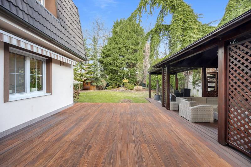 A family house in Ivanka pri Dunaji with a terrace made of flooring with a wooden decor and a garden.