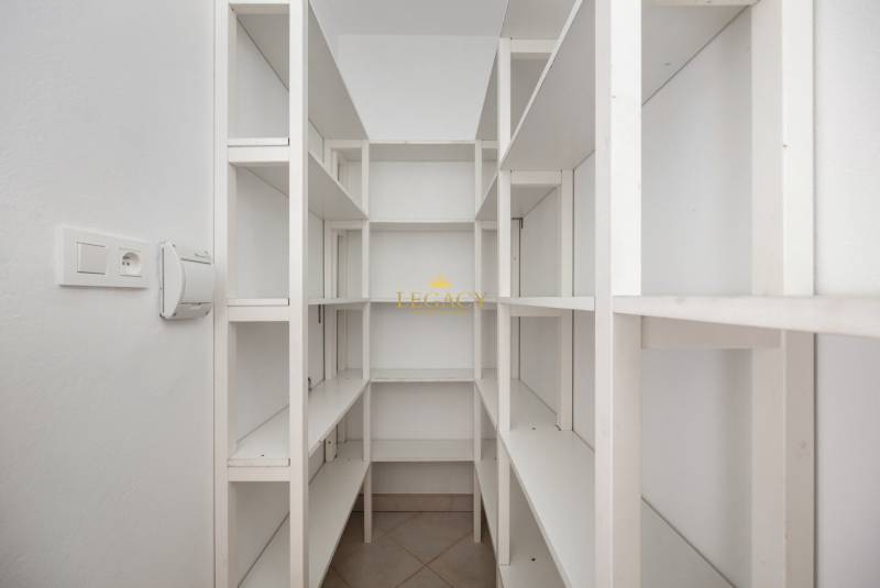 White storage room with shelves in a family house, ideal for storage solutions.