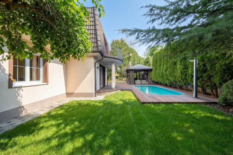 A family house in Ivanka pri Dunaji with a swimming pool and a gazebo amidst greenery.