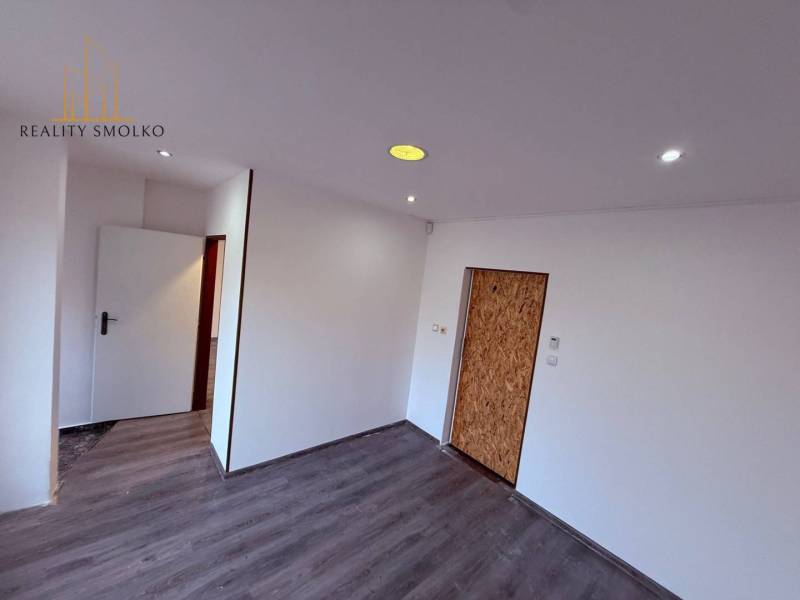 Interior of commercial spaces with white walls and a floor with a wooden decor.