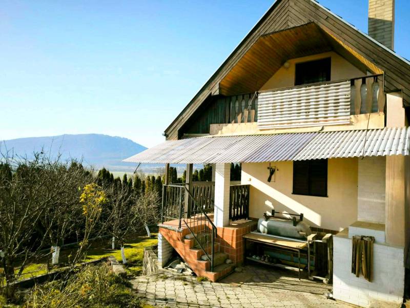 A cottage in Partizánske with a view of the mountains, surrounded by a garden and trees.