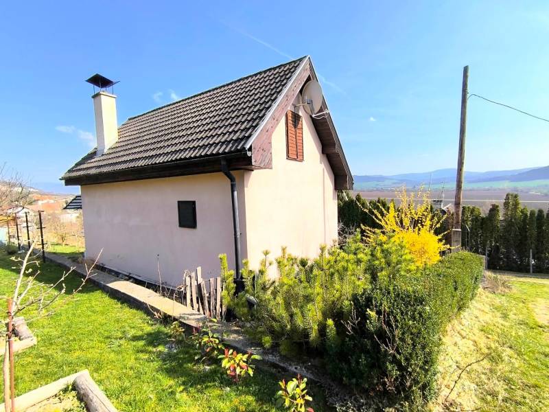 A cottage near Partizánske with a view of the surrounding landscape and a well-maintained garden.