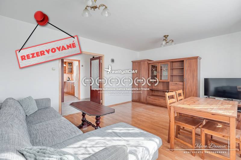 Living room in a three-room apartment with a wooden decor floor and a comfortable sofa.