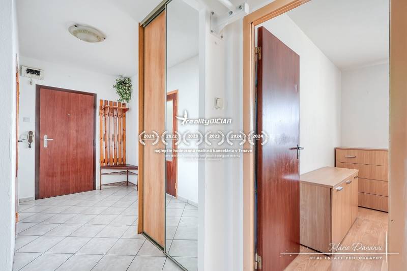 A hallway with a mirrored wardrobe and ceramic tiles in a 3-room apartment.