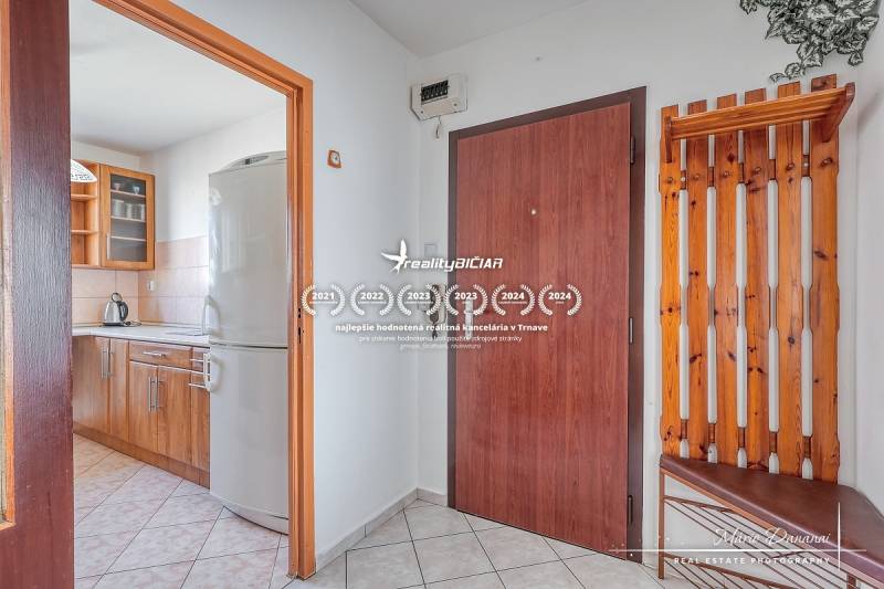 Interior of a 3-room apartment with a kitchen and wooden decor in the hallway.