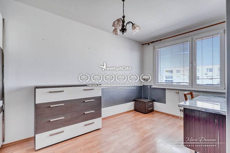 A room with prismatic lighting, white furniture, and a wood-patterned floor.
