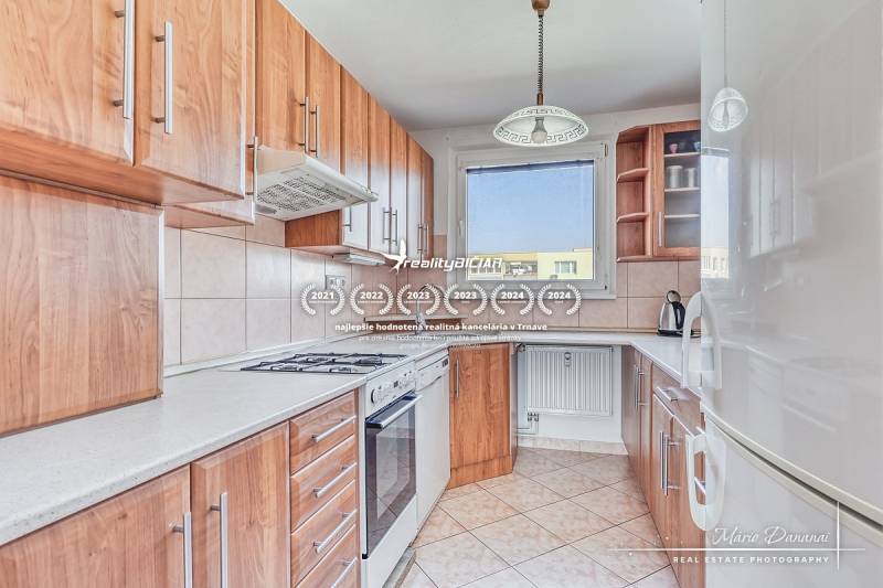 A kitchen in a 3-room apartment with wooden decor and light tiles.