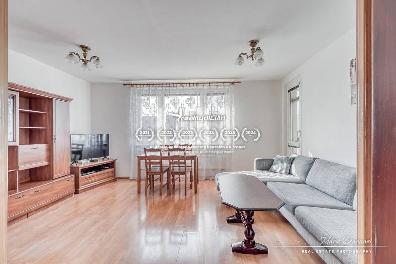 Living room in a 3-room apartment with a wooden decor floor and a sofa set.