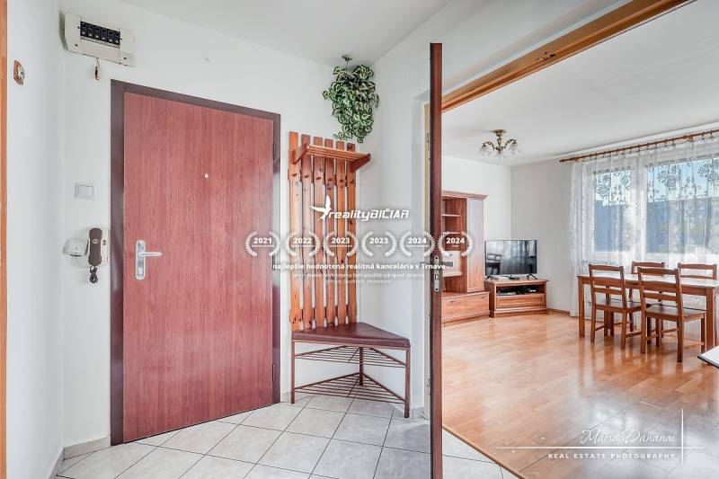 Entrance hall of a 3-room apartment with a coat rack wall, wooden decor, and dining area.