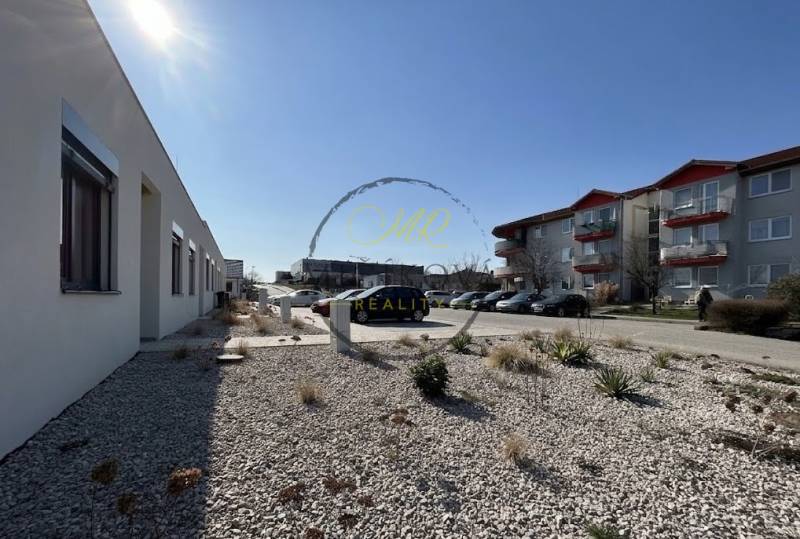 A family house in Klasov with parking, gravel landscaping, and an adjacent apartment building.