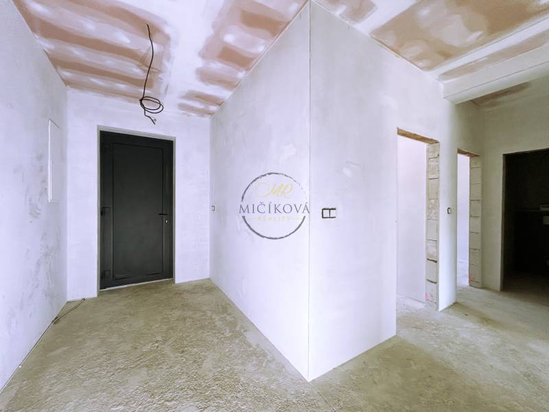 Interior of a family house with a concrete floor and white walls in the finishing stage.