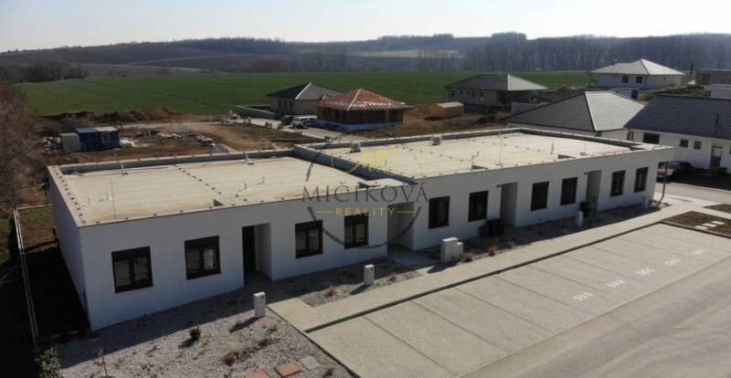 A family house in Klasov with a flat roof and parking space, surrounded by countryside.