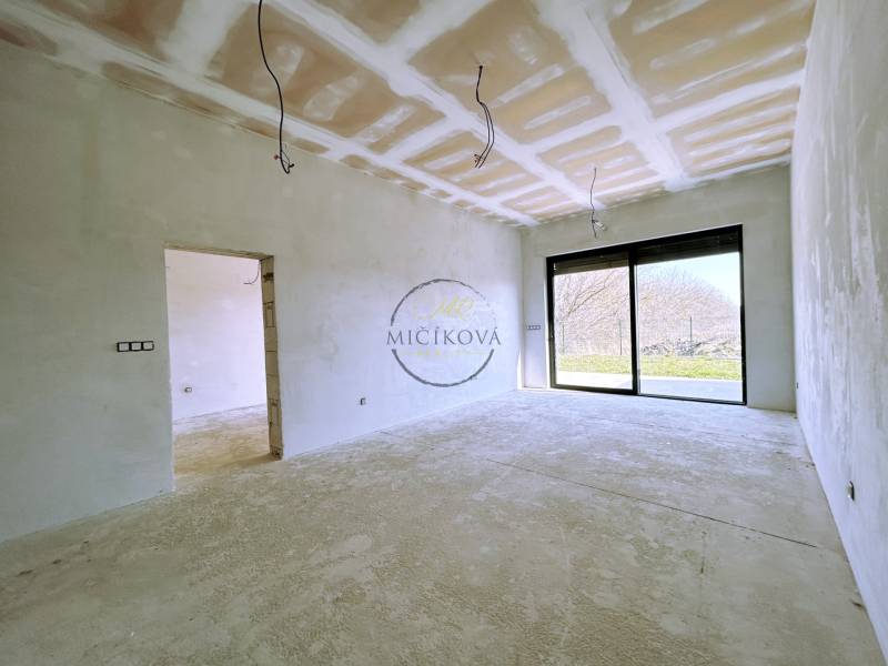 A large room in a family house with a view of the garden through a big window.
