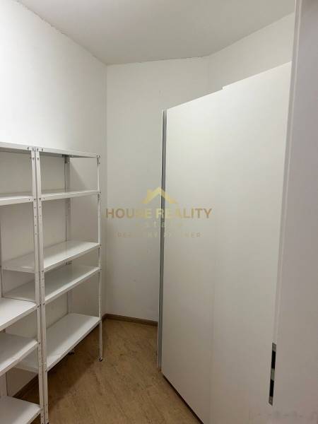 A small storage room with shelving units and a floor with a wooden decor in a 3-room apartment.
