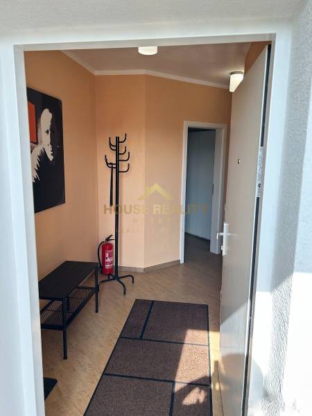 A hallway with a coat rack and a floor with a wooden decor in a 3-room apartment.