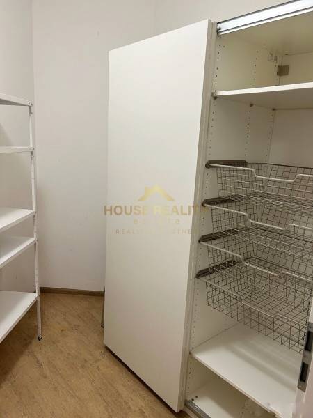 Storage space with shelves and wire baskets in a 3-room apartment.