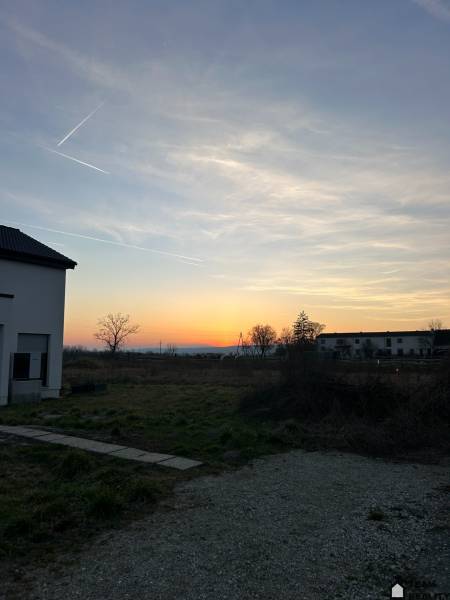 Sunset over residential lands in Neusiedl am See with visible houses.