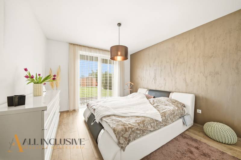 Bedroom in a family house with a double bed and a floor with a wooden decor.