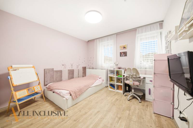 Children's room in a family house with wooden decor, furniture, toys, and a bed.