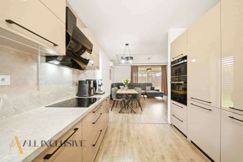Kitchen and living room in a family house with a wooden decor floor and modern furnishings.