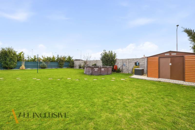 A garden of a family house in Dunajská Streda with a lawn, a gazebo, and a swimming pool.