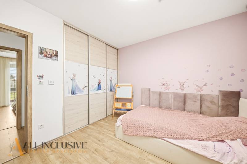 Children's room with cartoon motifs in a family house, floor with wooden decor.
