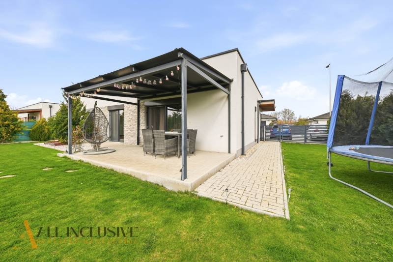 A family house in Dunajská Streda with a terrace, garden, and a trampoline on the grass.