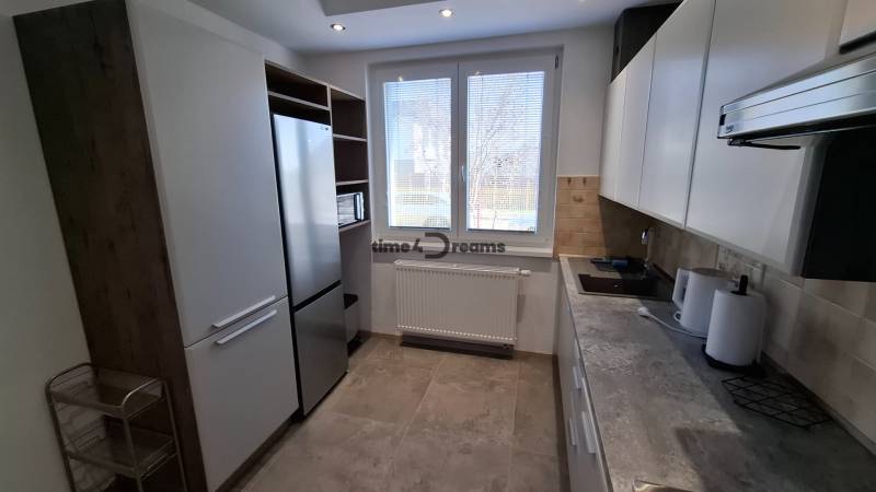 A kitchen in a 2-room apartment with white cabinets and appliances.