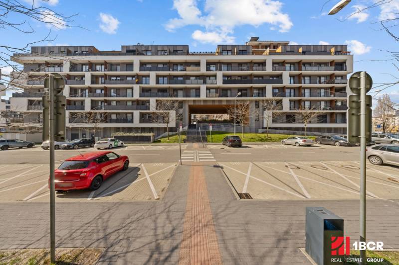 Apartment building near Zuzany Chalupovej Street, Bratislava - Petržalka, with parking in front of the building.