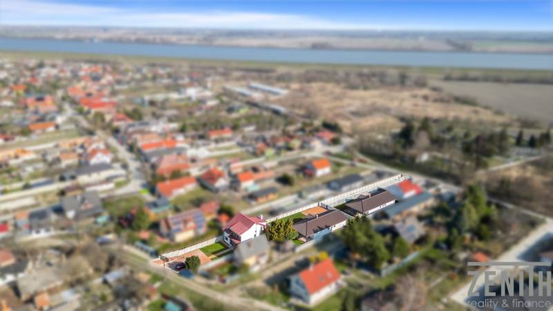 Aerial view of family houses in Vojka nad Dunajom with surrounding landscape and river.