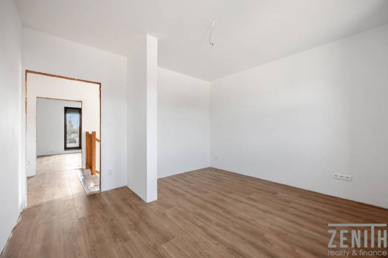 Interior of a family house with a wood-patterned floor and white walls.