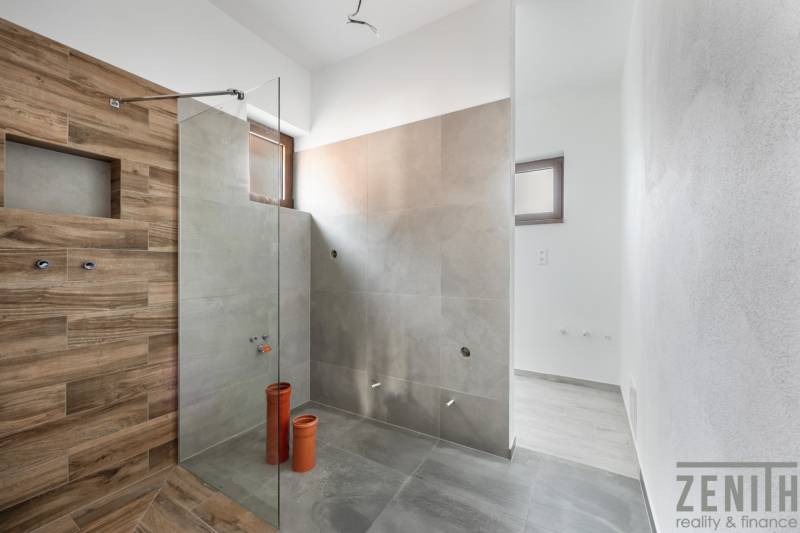 A bathroom with ceramic tiles and a shower enclosure in a family house.
