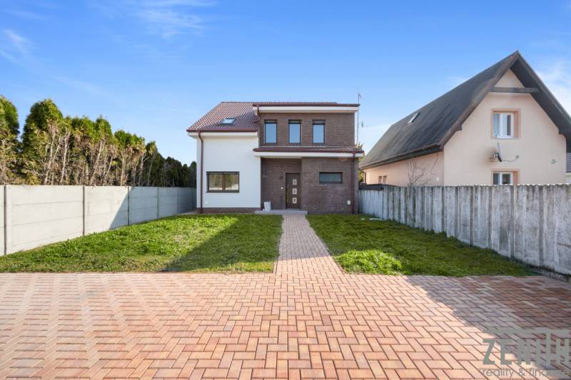 A family house in Vojka nad Dunajom with brick cladding and a garden.