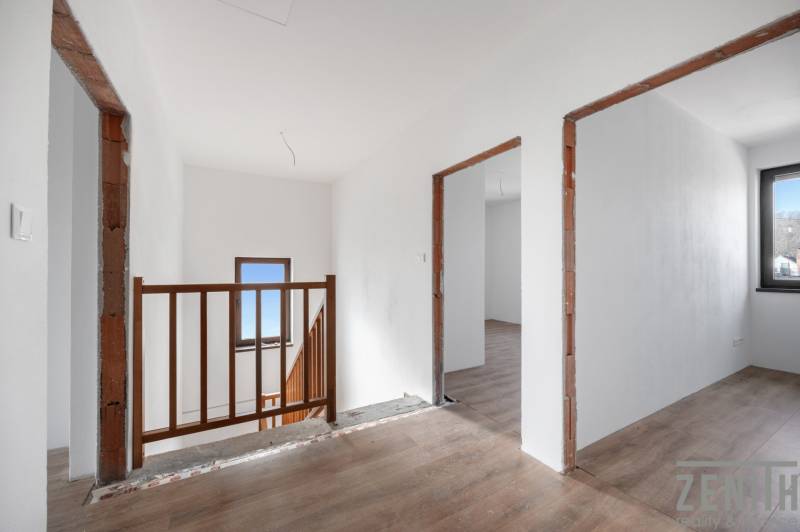 A hallway in a family house with a wooden decor floor and wooden railing.