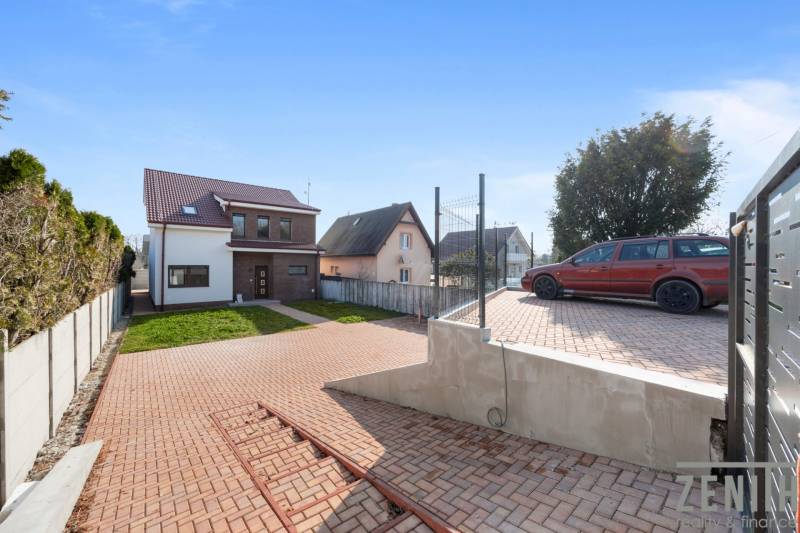 A family house in Vojka nad Dunajom with a landscaped yard, parking space, and lawn.