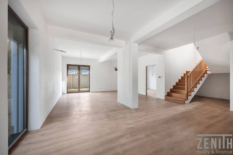 Interior of a family house with an open space and staircase, floor with wood decor.