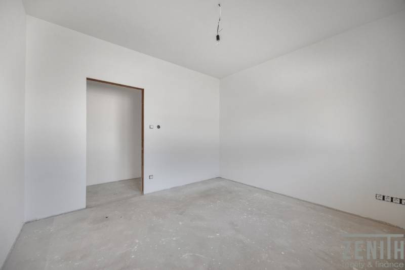 Drywall walls in an unfinished room of a family house with an exposed light bulb.