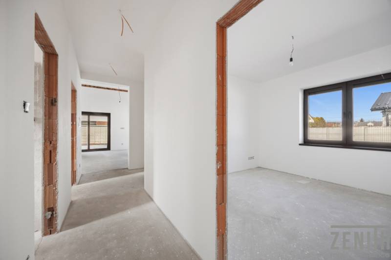 The interior of a family house with unfinished doors, large windows, and the layout of the rooms.